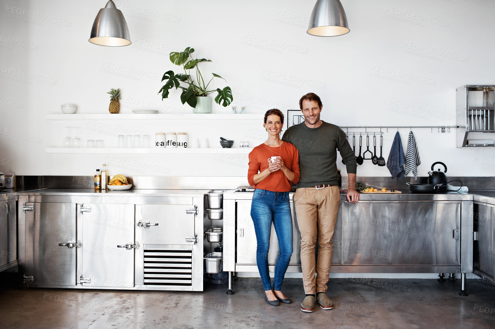 Buy stock photo Portrait of a smiling mature couple standing in their kitchen