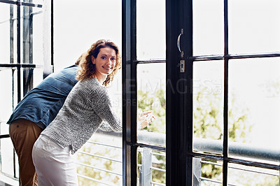 Buy stock photo Shot of a mature couple leaning on their balcony railing looking outside