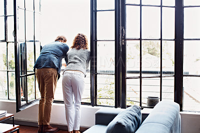 Buy stock photo Rearview shot of a mature couple leaning on their balcony railing looking outside