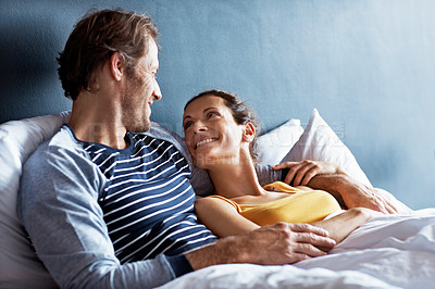 Buy stock photo Shot of a content mature couple lying in bed together