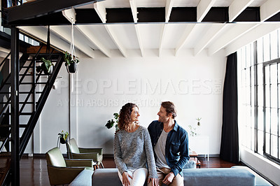 Buy stock photo Shot of a content mature couple leaning on a sofa in their living room