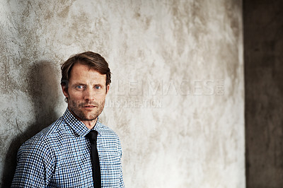 Buy stock photo Portrait of a businessman in a shirt and tie leaning against a wall
