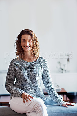 Buy stock photo Portrait of a mature woman leaning on a sofa in her living room