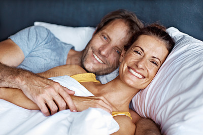 Buy stock photo Portrait of an affectionate mature couple lying in bed together
