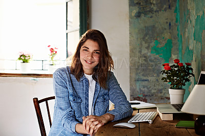 Buy stock photo Portrait of a smiling young woman sitting at a work desk at home