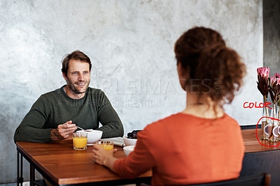Buy stock photo Shot of a smiling couple eating breakfast at their kitchen table