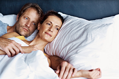 Buy stock photo Shot of a content couple lying in bed together
