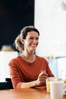Buy stock photo Shot of a smiling mature woman eating breakfast