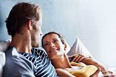 Buy stock photo Shot of a content couple lying in bed together