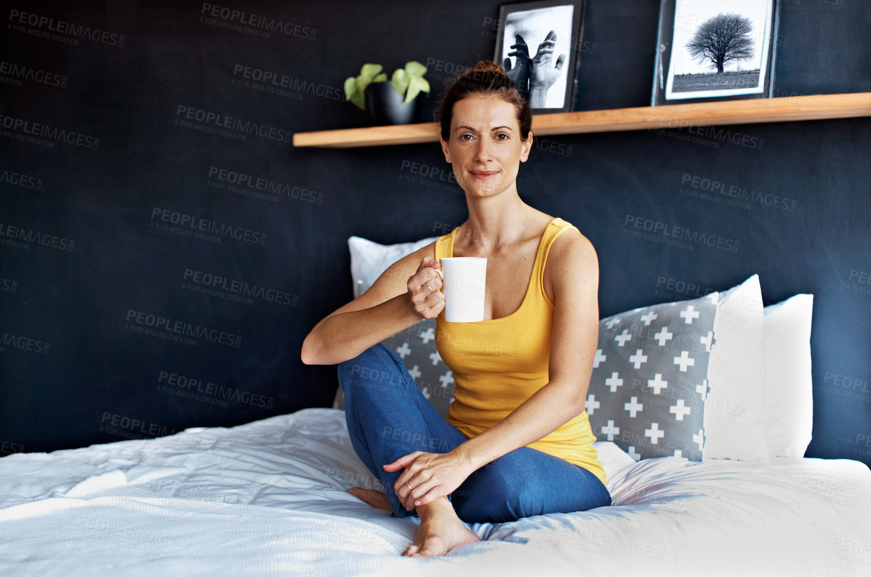 Buy stock photo Portrait of a smiling mature woman drinking coffee while sitting on her bed