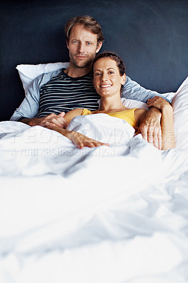 Buy stock photo Portrait of a smiling mature couple lying in bed