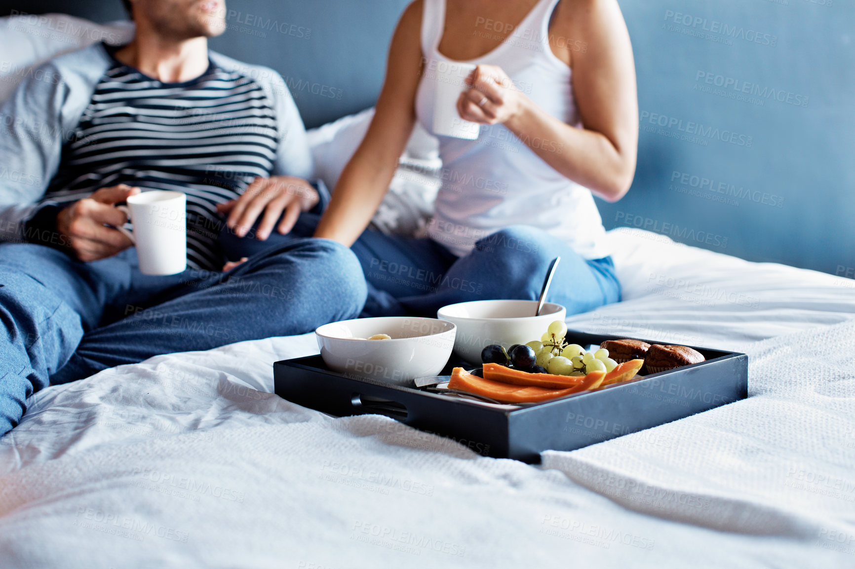 Buy stock photo Breakfast, hands and tray with couple in bed of home for bonding, anniversary celebration and love. Morning fruit, connection and marriage commitment with man and woman in bedroom of house for food