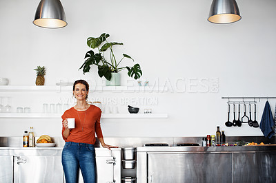 Buy stock photo Portrait of a smiling mature woman standing in her kitchen drinking coffee