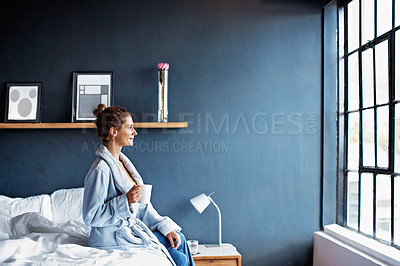 Buy stock photo Shot of a mature woman sitting on her bed drinking a coffee