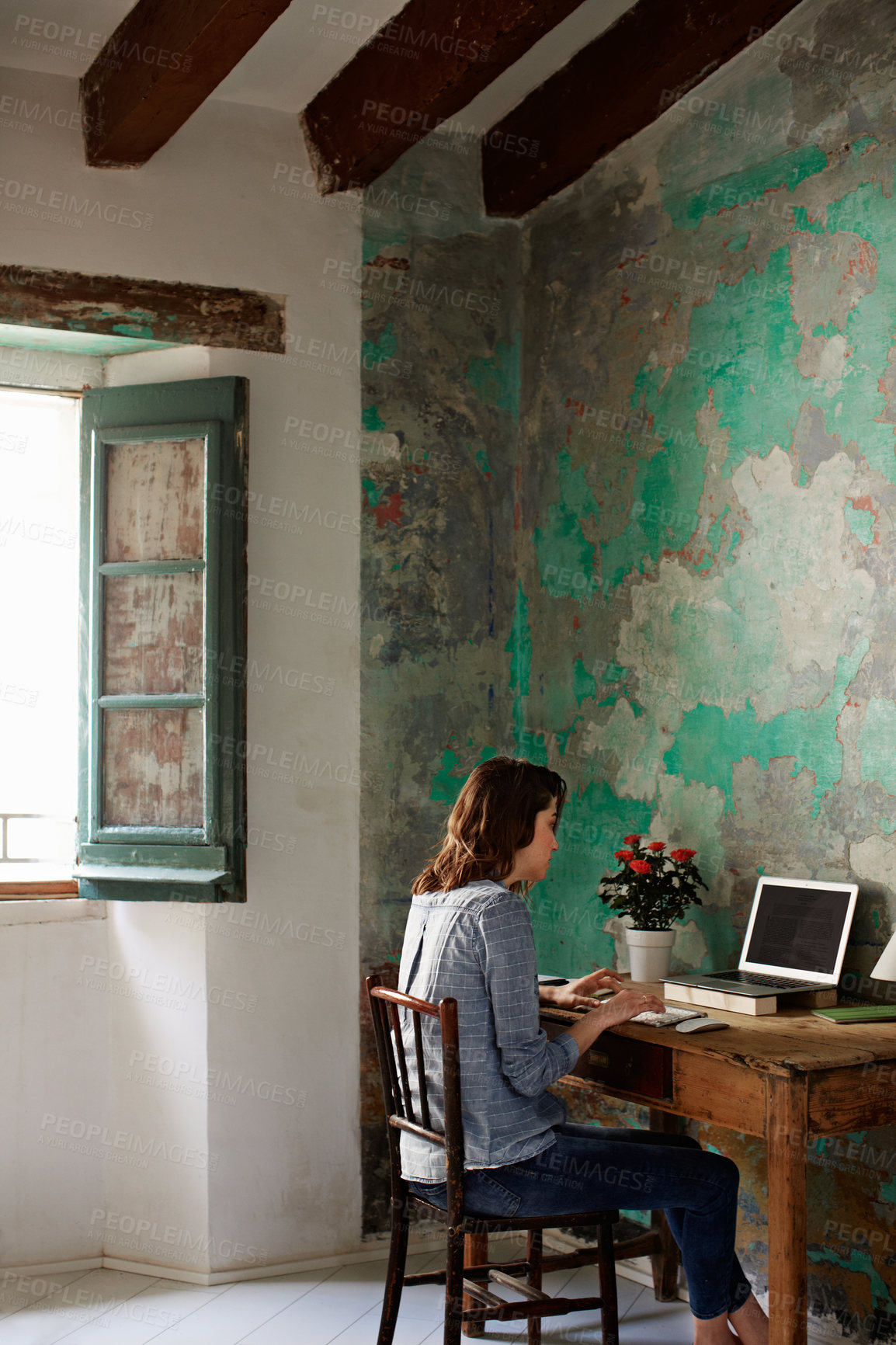 Buy stock photo Shot of a young woman sitting at a work desk at home working on a laptop