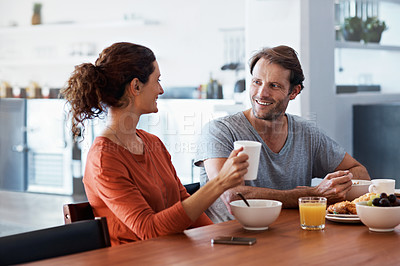 Buy stock photo Shot of a content couple enjoying breakfast together at home