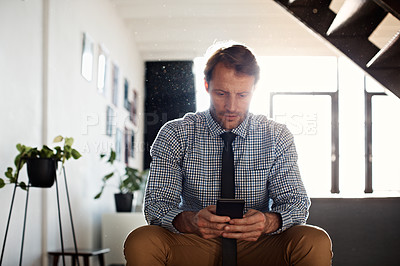 Buy stock photo Shot of a businessman sending a text message while sitting at home