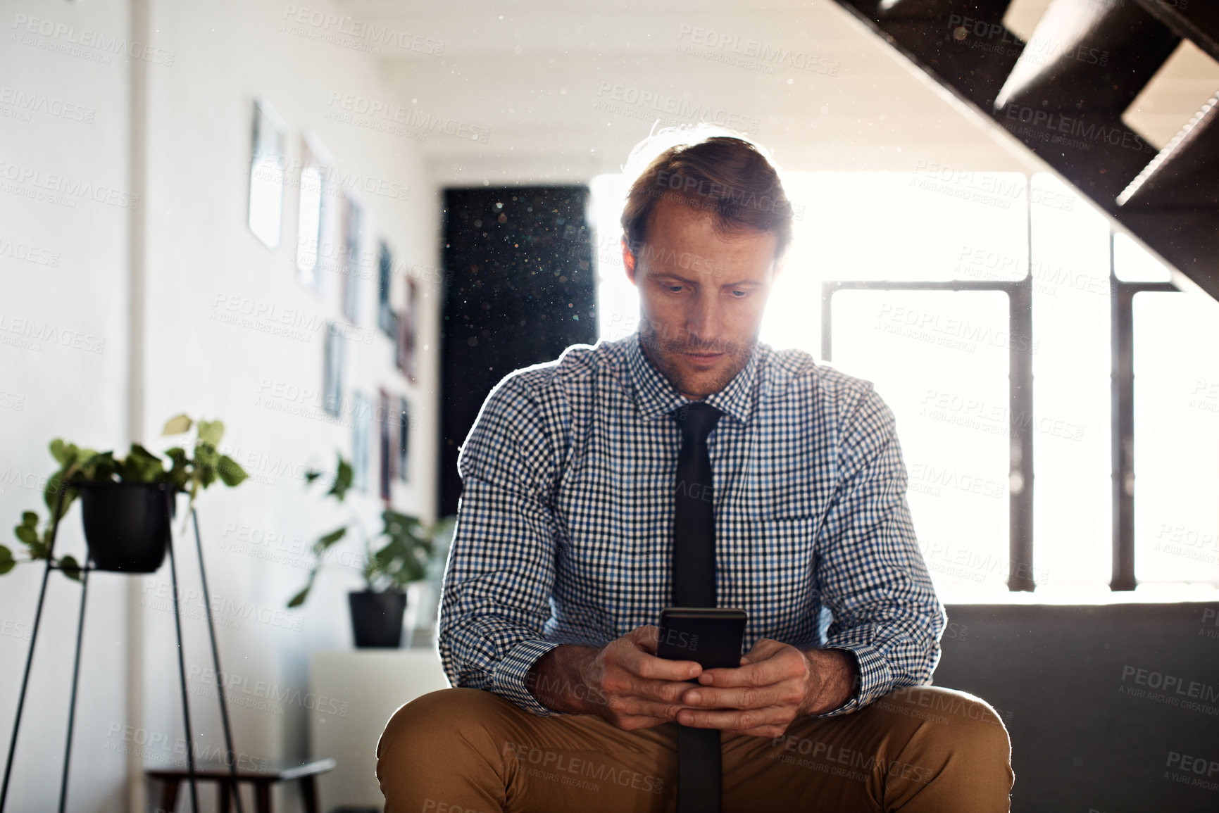 Buy stock photo Shot of a businessman sending a text message while sitting at home