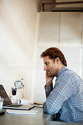 Buy stock photo Shot of a businessman at work on a laptop in an office