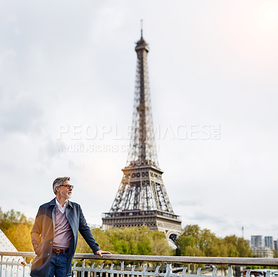 Buy stock photo Shot of a handsome mature man leaning on a railing in Paris with the Eiffel Tower in the backgournd