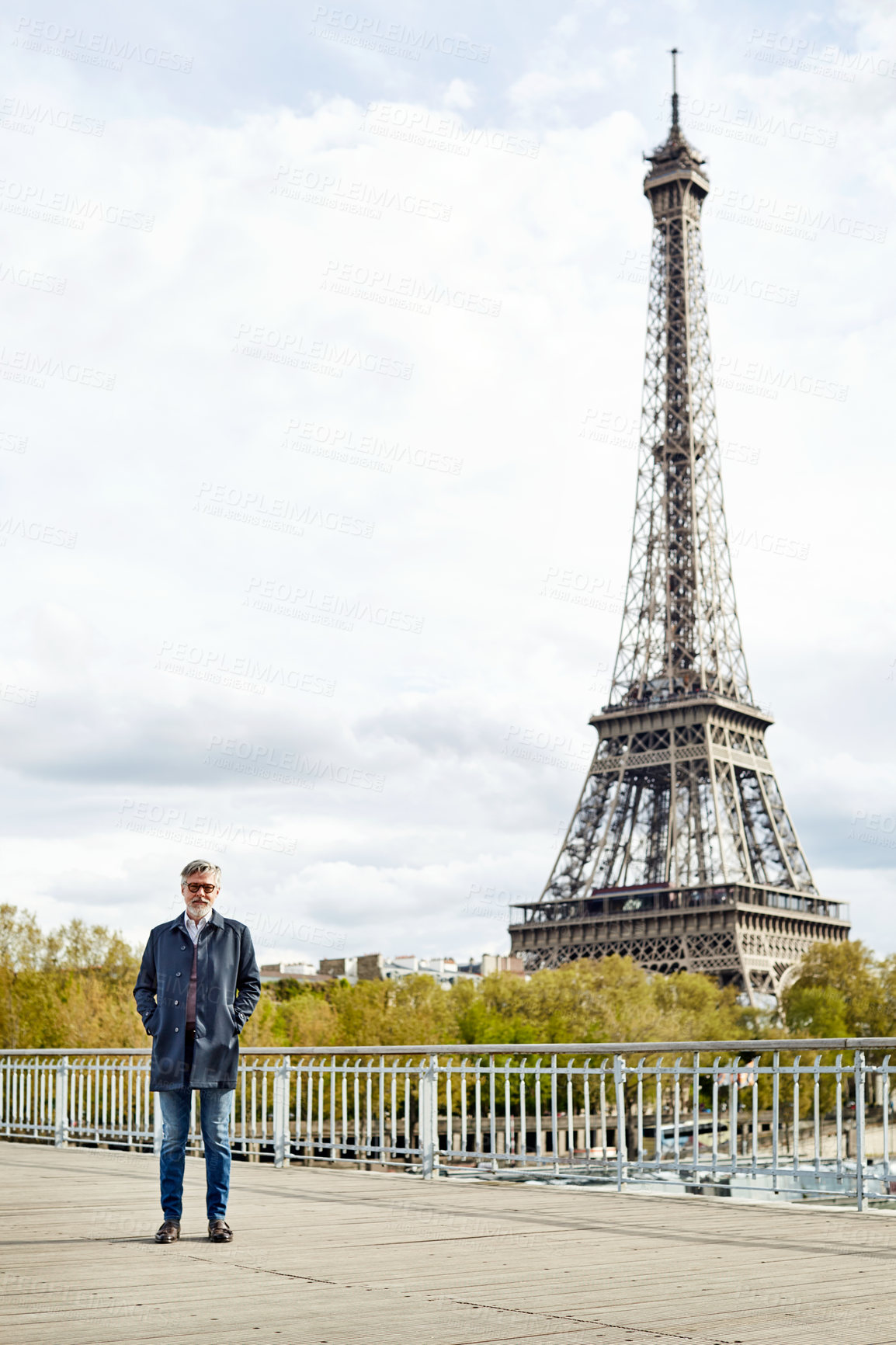 Buy stock photo Mature, man and travel in city with Eiffel tower for outdoor vacation or holiday trip in France. Portrait, male person or traveler with building landmark for weekend or sightseeing in Paris or town