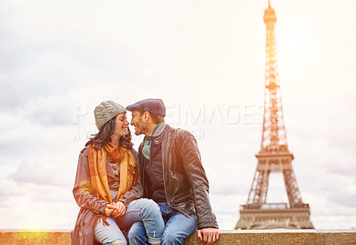 Buy stock photo Shot of a happy young couple sitting together in front of the Eiffel Tower