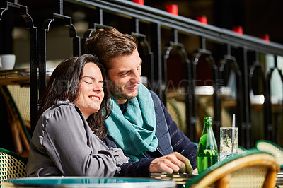Buy stock photo Shot of a smiling couple sitting together at a table at a sidewalk cafe