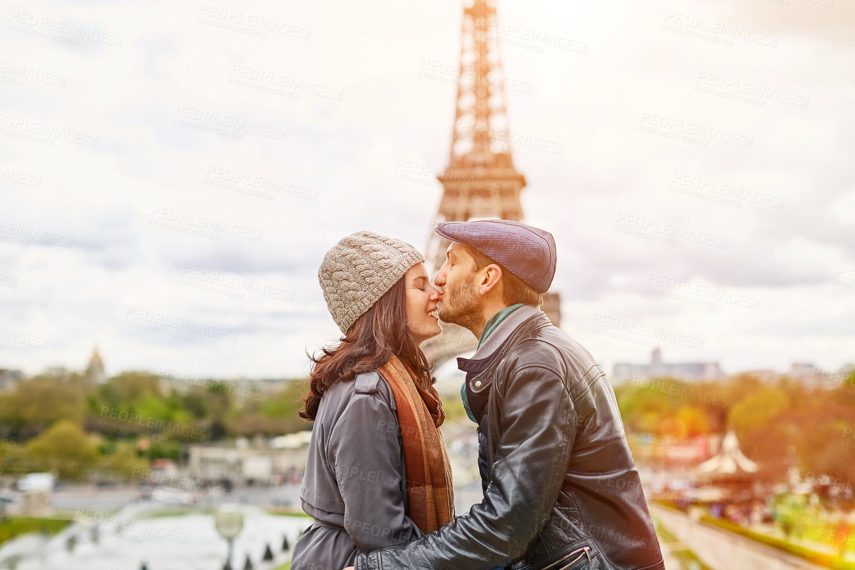 Buy stock photo Shot of a happy young couple kissing together in front of the Eiffel Tower