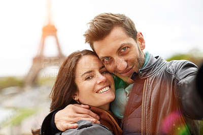 Buy stock photo Shot of a happy young couple talking a selfie together in front of the Eiffel Tower