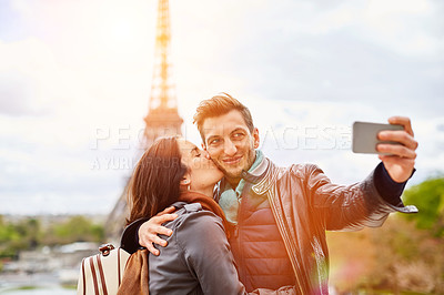 Buy stock photo Shot of a happy young couple talking a selfie together in front of the Eiffel Tower