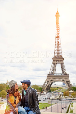 Buy stock photo Shot of a happy young couple sitting together in front of the Eiffel Tower