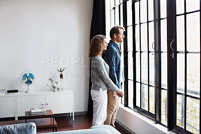 Buy stock photo Shot of an affectionate mature couple standing together in front of a window at home