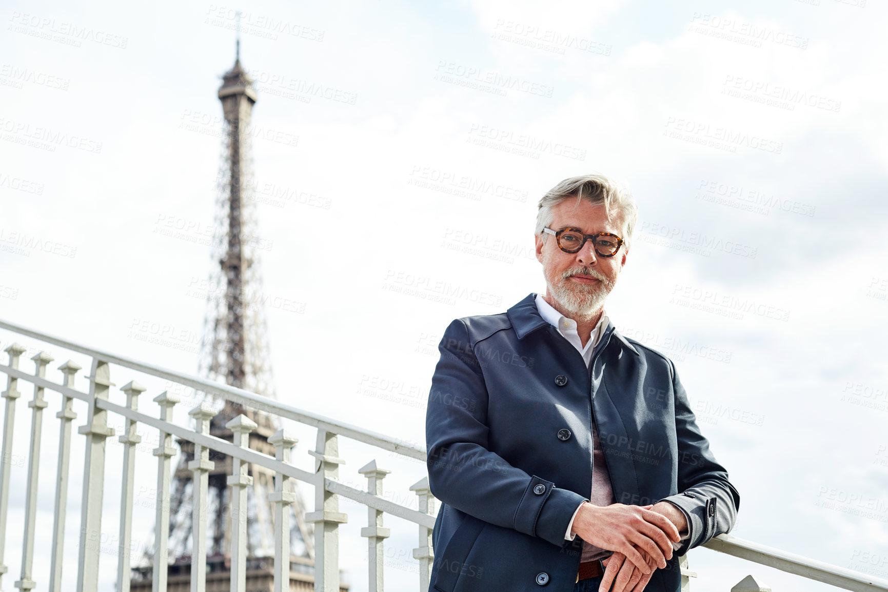 Buy stock photo Shot of a handsome mature man leaning on a railing in Paris with the Eiffel Tower in the background