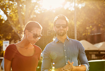 Buy stock photo Shot of an affectionate young couple walking together in the city