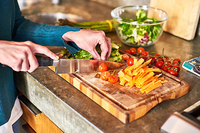 Buy stock photo Closeup shot of a woman chopping vegetables on her kitchen counter