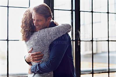Buy stock photo Shot of an affectionate mature couple hugging in front of a window at home