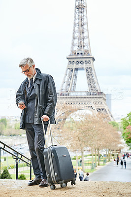 Buy stock photo Shot of a handsome mature man using a cellphone in Paris with the Eiffel Tower in the background