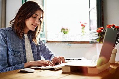 Buy stock photo Shot of a young woman sitting at a desk in her room using a computer