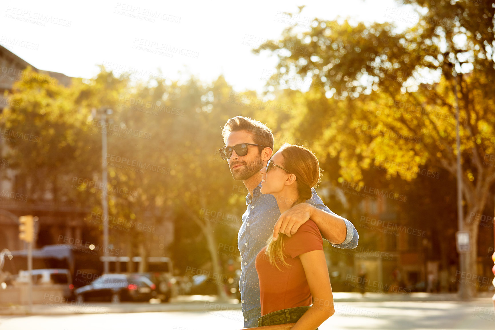 Buy stock photo Shot of an affectionate young couple walking together in the city