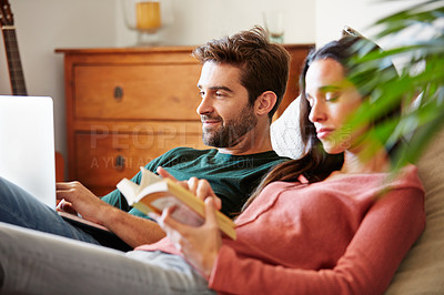 Buy stock photo Shot of a smiling young couple relaxing together on a beanbag sofa at home
