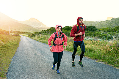Buy stock photo Shot of two friends out for a run together on a cool morning