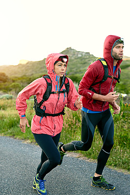 Buy stock photo Shot of two friends out for a run together on a cool morning