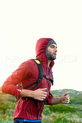 Buy stock photo Shot of a focused young man out for a run on a cool morning