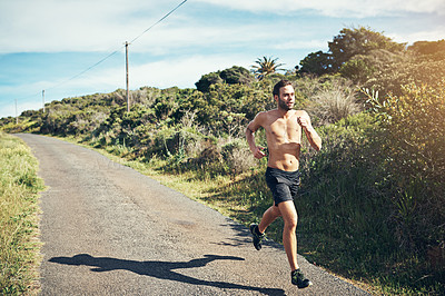 Buy stock photo Shot of a bare chested young man out for an early morning run