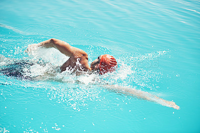 Buy stock photo Shot of an athletic young man swimming in a pool