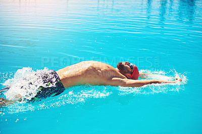 Buy stock photo Shot of an athletic young man swimming in a pool
