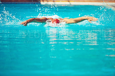 Buy stock photo Shot of an athletic young man swimming in a pool
