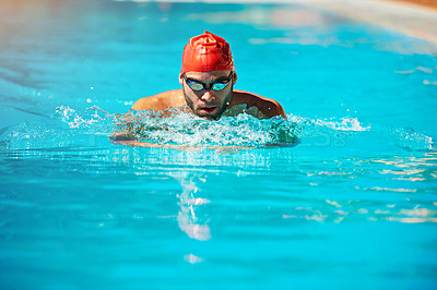 Buy stock photo Shot of an athletic young man swimming in a pool