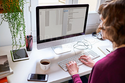 Buy stock photo Shot of a young woman working on a computer while sitting at a desk in her home office