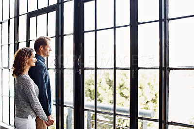 Buy stock photo Shot of an affectionate mature couple standing together in front of a window at home